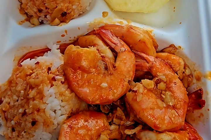 Garlic shrimp served with rice and a slice of pineapple