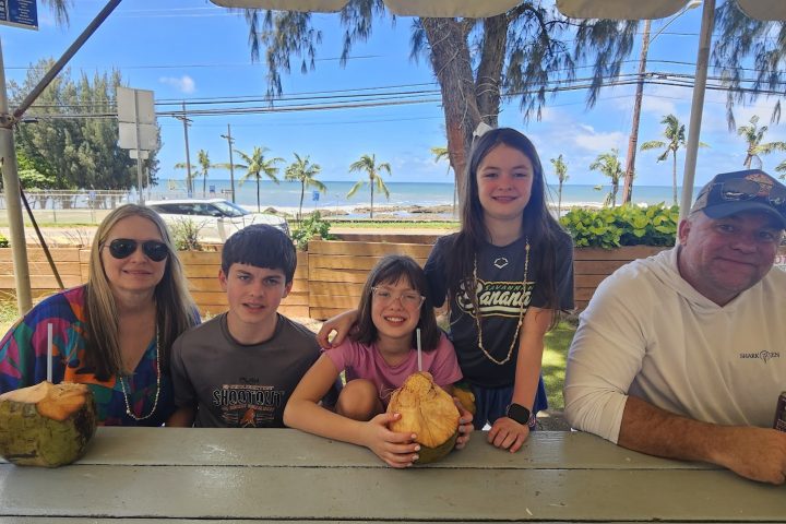 Family enjoying coconuts during a private North Shore Oahu tour